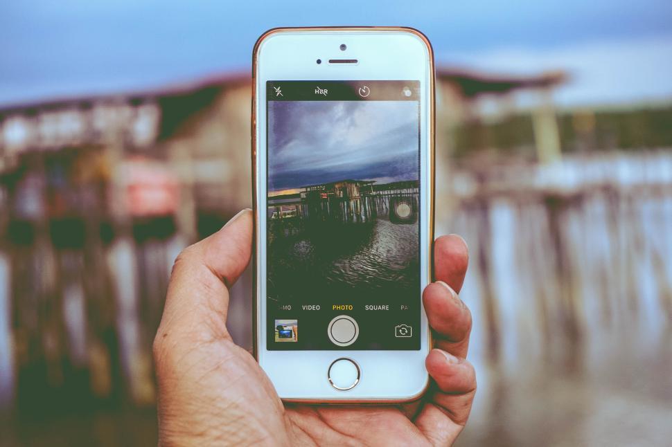 Free Image of Hand holding smartphone capturing beautiful seascape 