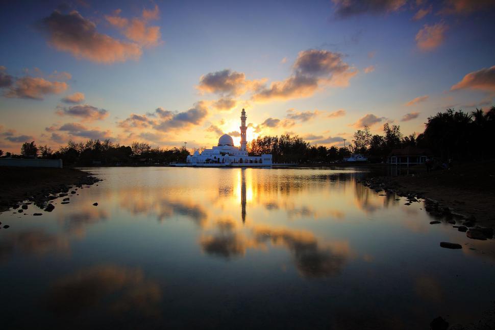 Free Image of Mosque reflected in water at sunset with dramatic sky. 