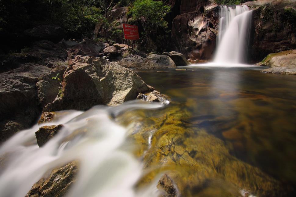 Free Image of Beautiful waterfall cascading over moss-covered rocks 