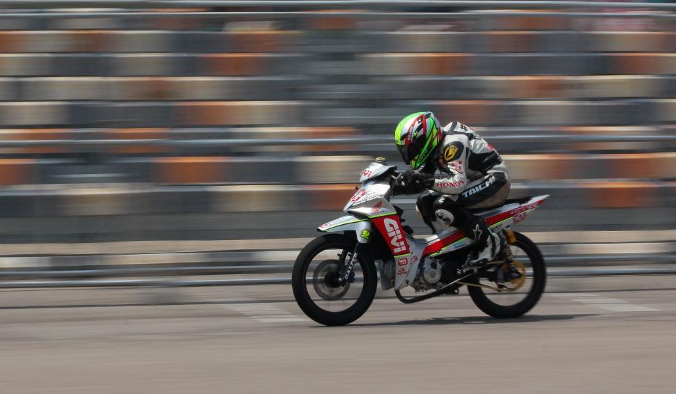Free Image of Speeding motorcycle racer on track showcasing motion blur 