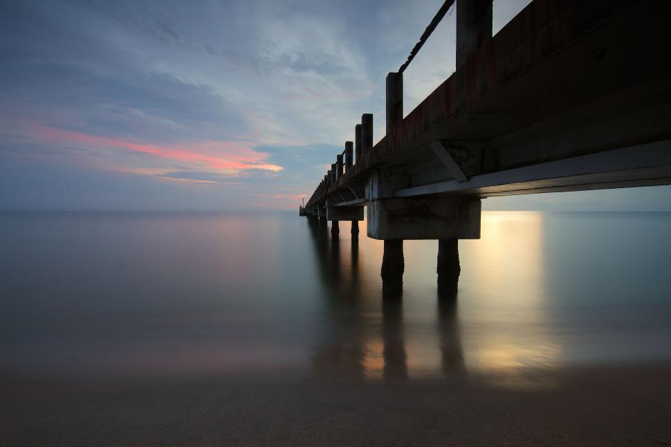 Free Image of Moody abandonment pier with serene waters at sunrise 