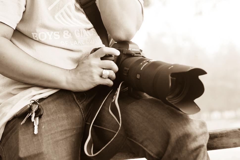 Free Image of Photographer holding camera with long lens attachment 