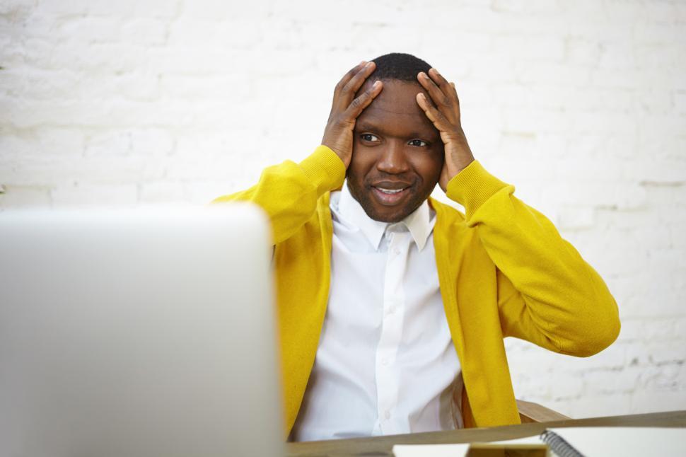 Free Image of Worried Afro American businessman using laptop in office, feeling stressed with bankruptcy news, financial problem, debt, fail, unexpected computer mistake or error crash, forgot about deadline 