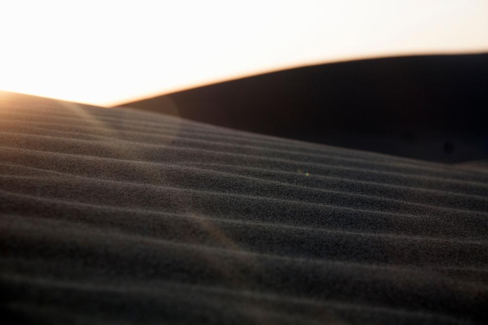 Free Image of Ridges and shadows of sand dunes at sunset in desert 