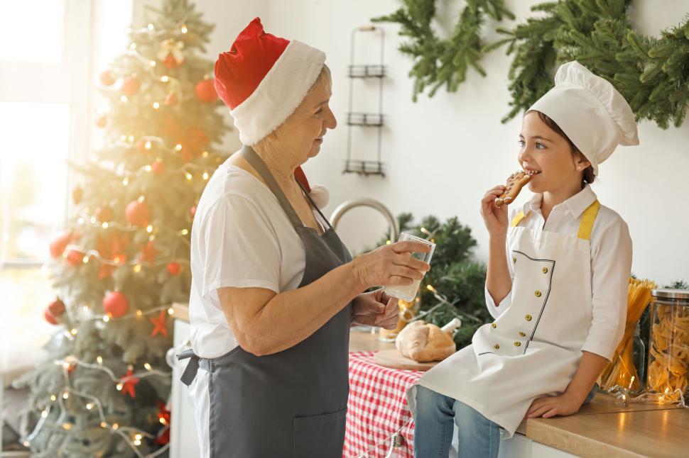 Free Image of Older Woman and Grandchild Cooking with Holiday Decorations. 