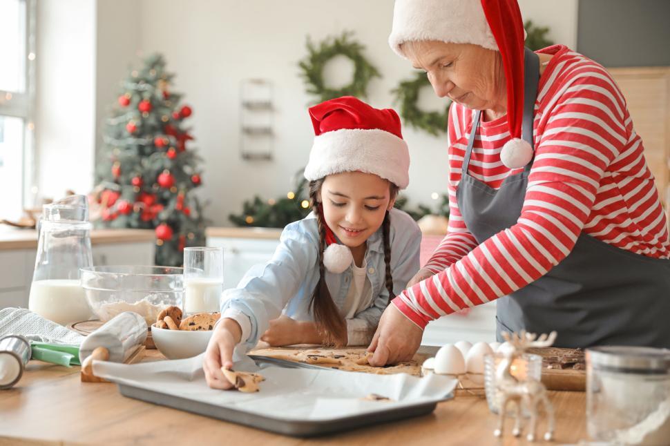 Free Image of Grandmother Helping Young Girl Bake Cookies for Christmas. 