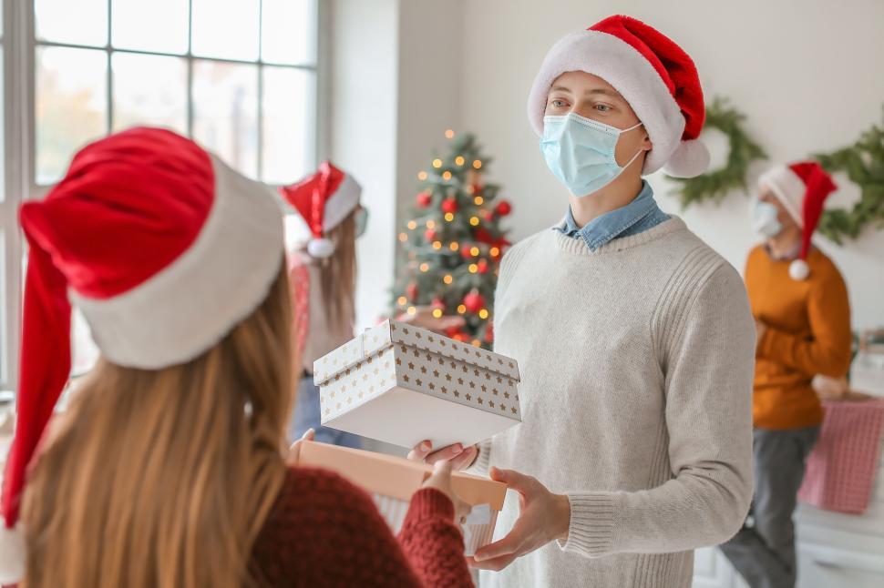 Free Image of People sharing Christmas gifts in a bright room. 
