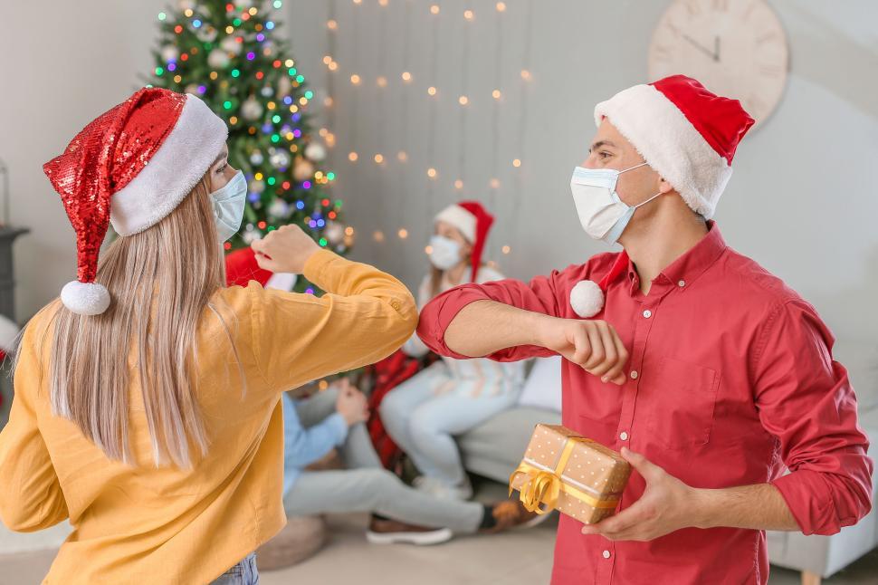 Free Image of People in Santa hats greeting with elbow bumps 