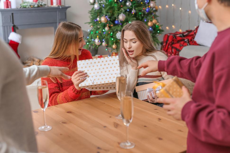 Free Image of Friends exchanging gifts at Christmas party celebration 