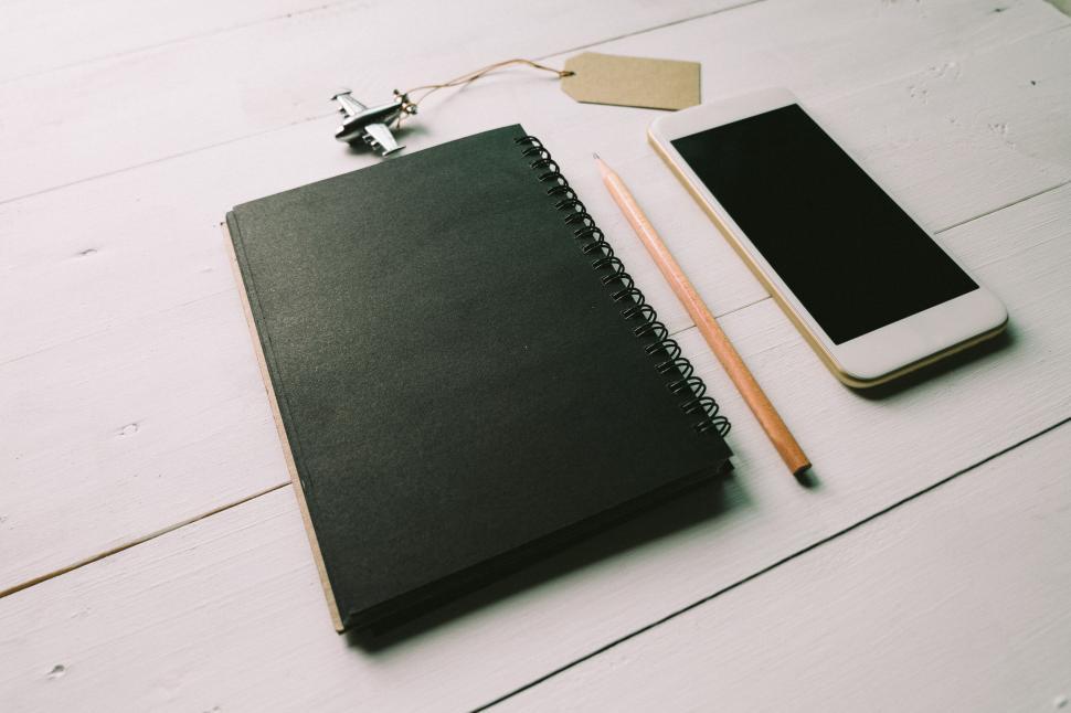 Free Image of A black notebook, pencil, and smartphone on a table. 