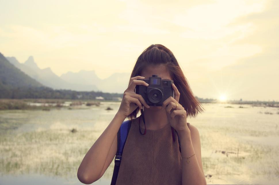 Free Image of Woman photographing nature in front of scenic landscape. 