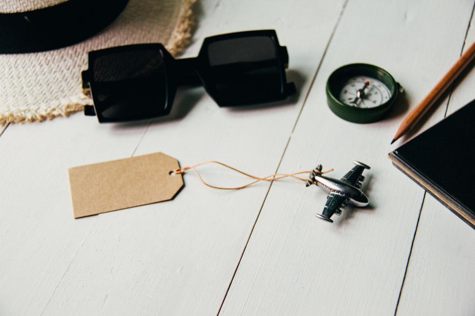 Free Image of Travel items and accessories arranged on white table top. 