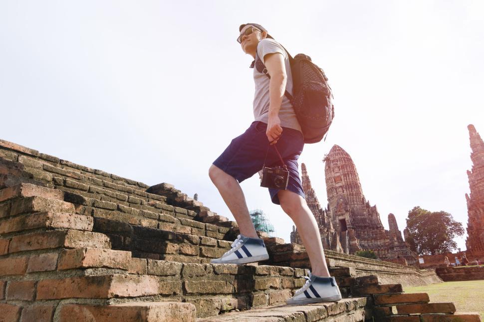 Free Image of Traveler climbing historic steps with backpack camera. 