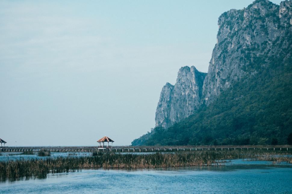 Free Image of Scenic lakeside landscape with mountains and pavilion view. 