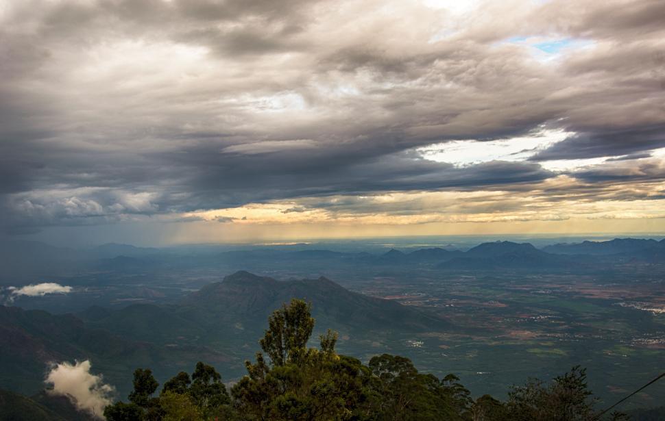 Free Image of Panoramic view of a vast landscape under a cloudy sky 