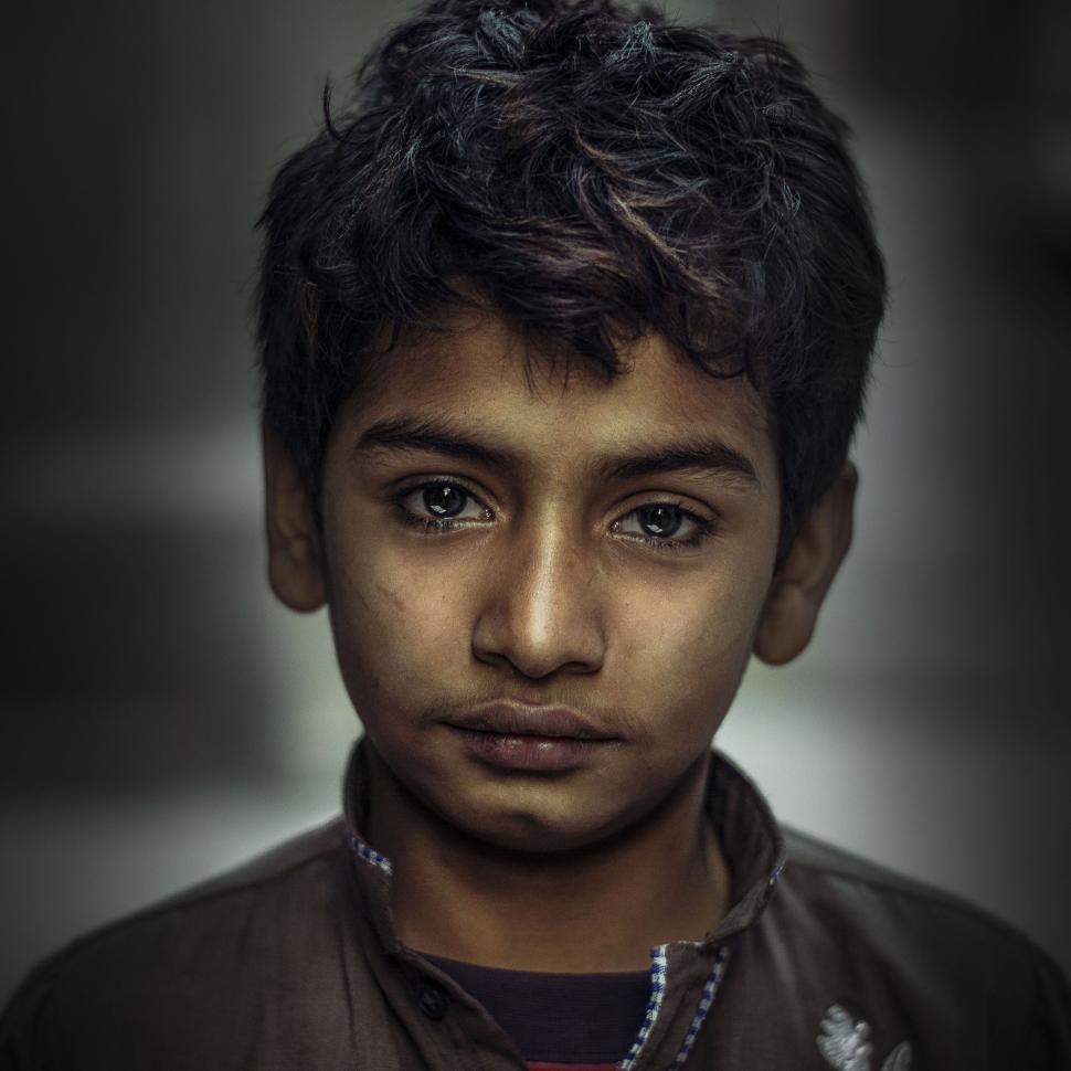 Free Image of Portrait of a young boy with intense gaze and dark hair 