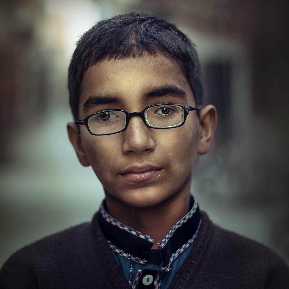 Free Image of Boy with glasses in thoughtful close-up portrait photo 