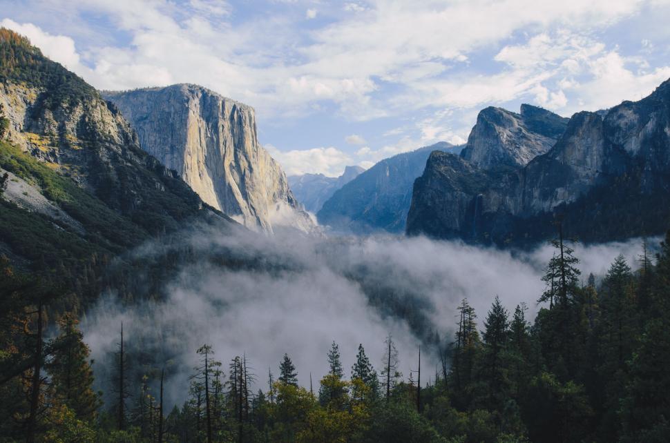 Free Image of Expansive landscape of mountains and a foggy valley. 