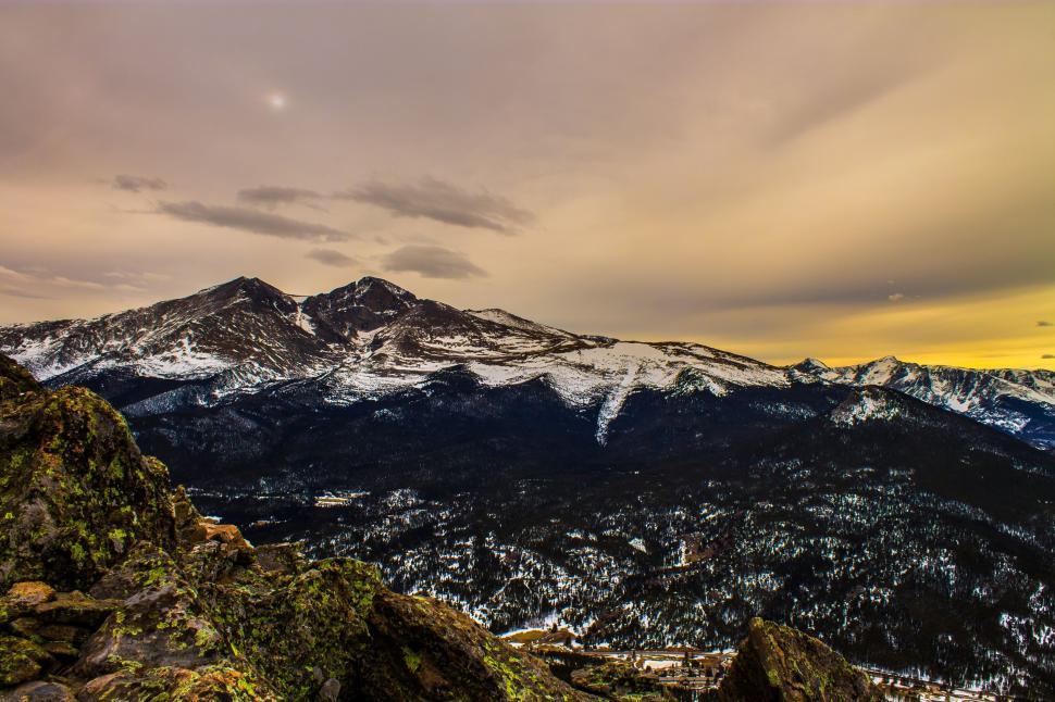 Free Image of Snowy mountain landscape during sunset with cloudy sky. 