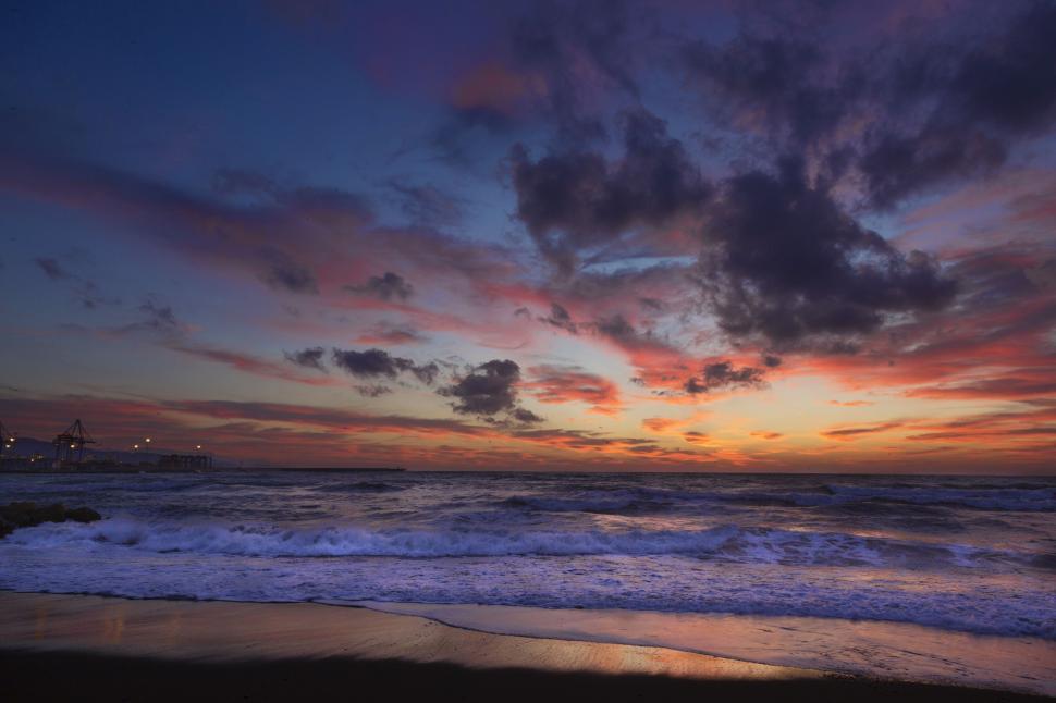 Free Image of Sunrise at beach with colorful sky and calm water. 