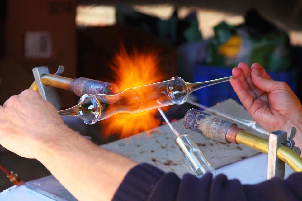 Free Image of Hands crafting glass with fire using traditional tools. 
