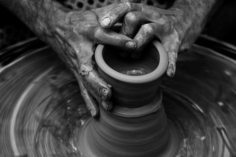 Free Image of Hands shaping a pottery piece on a spinning pottery wheel 