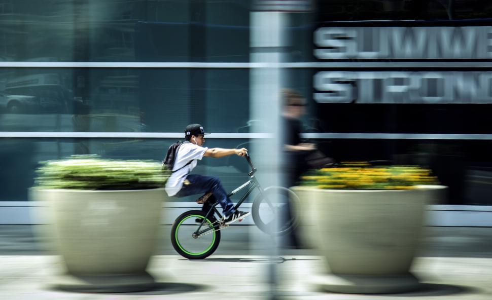 Free Image of Motion blur photograph of a BMX biker on the street 