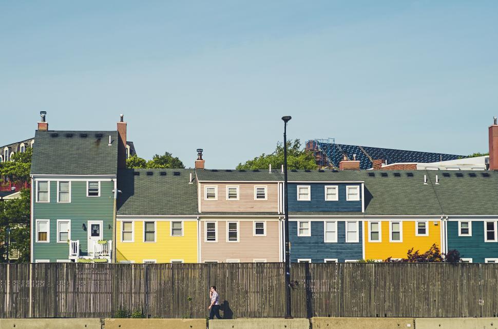 Free Image of Colorful row houses with person walking in foreground. 