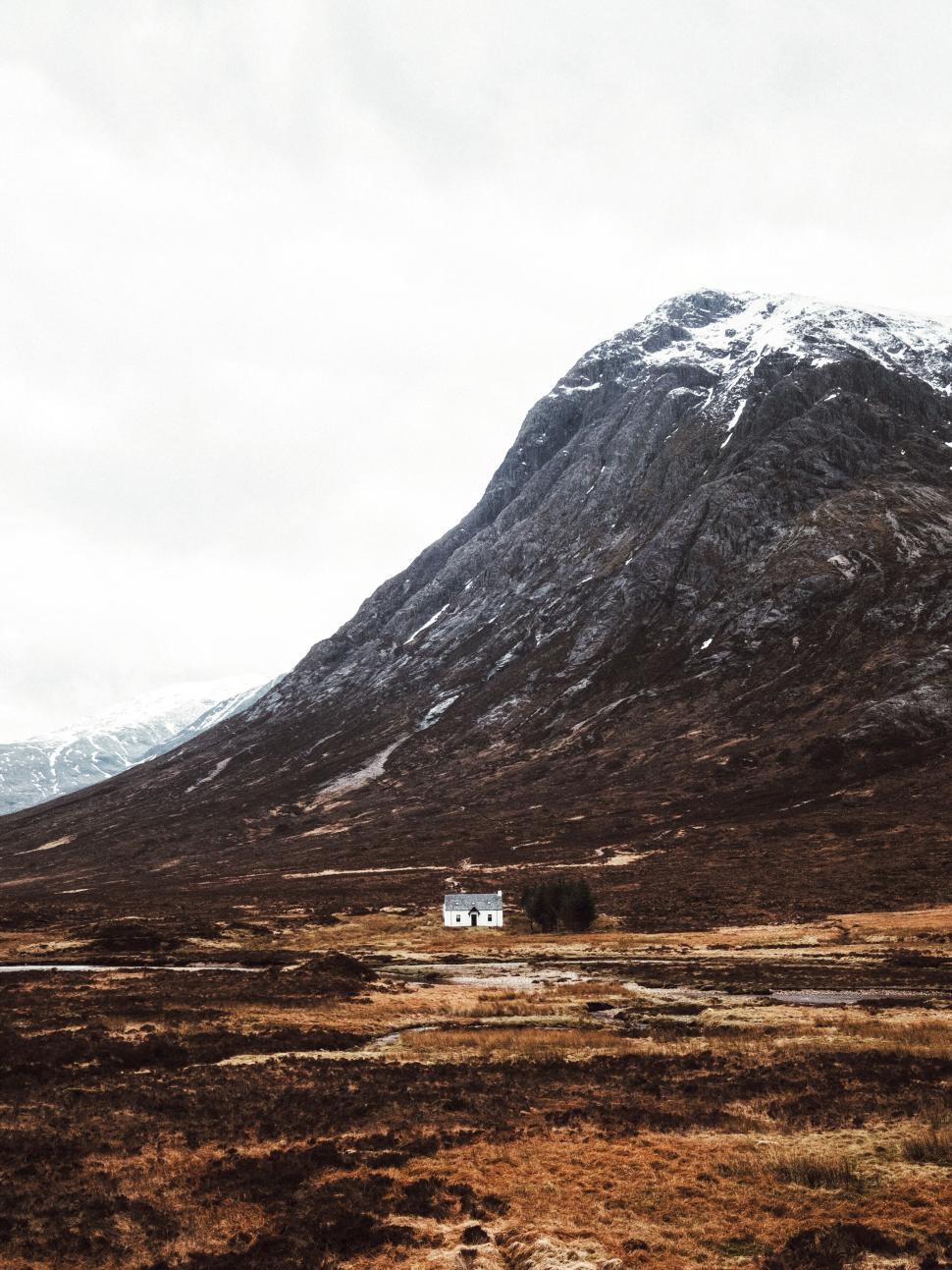 Free Image of A small house at the base of a large mountain peak. 