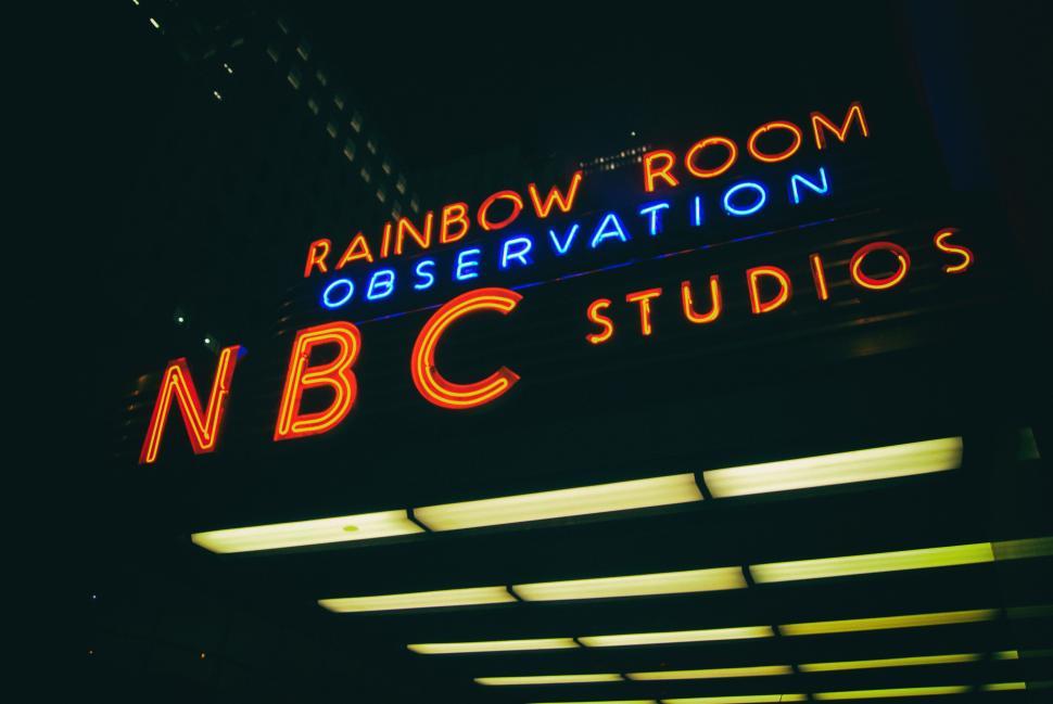 Free Image of Iconic NBC Studios sign at night with bright lights on. 