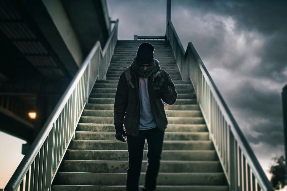 Free Image of Lone individual walking down an urban staircase at dusk. 