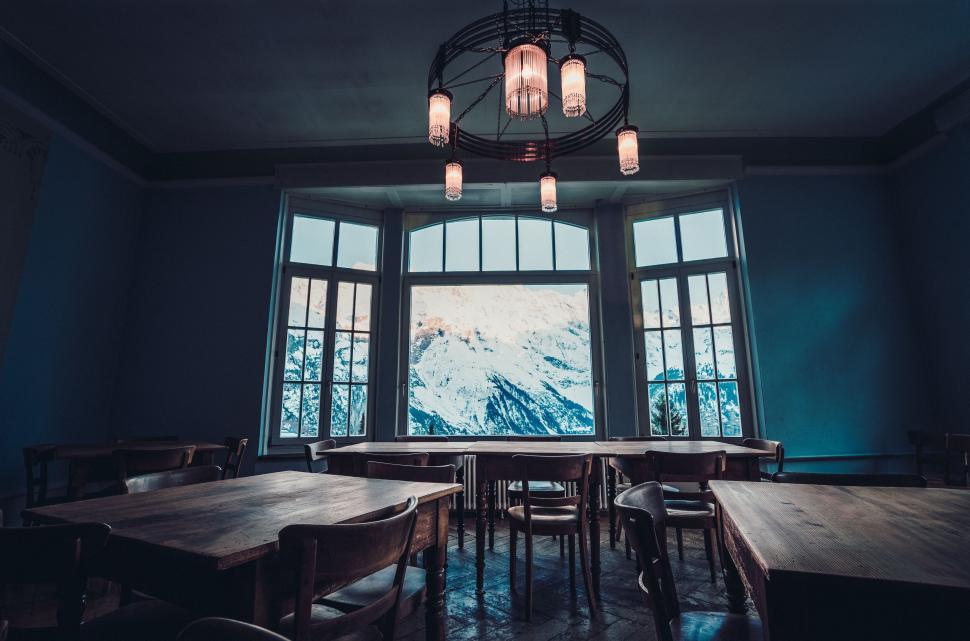 Free Image of Rustic dining room with window overlooking snowy mountains 
