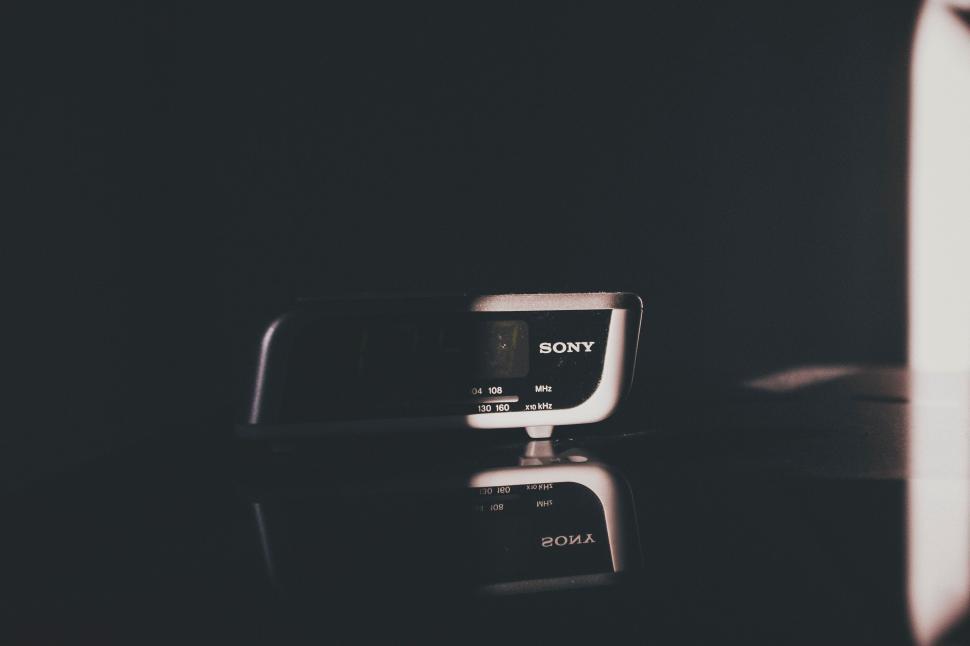 Free Image of Sony digital alarm clock spotlighted in dark room. 