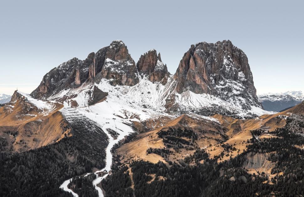 Free Image of Snow-capped mountains and a winding pathway in autumn. 