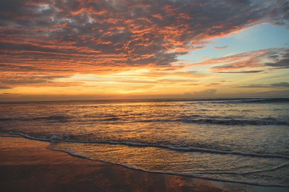 Free Image of Vivid sunset over a serene ocean with calm waves. 