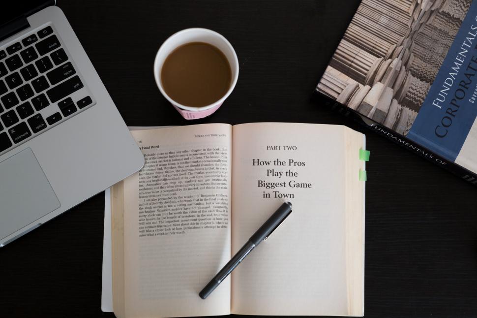Free Image of Open book with coffee, pen, and laptop on the table 