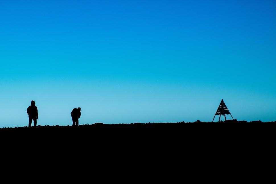 Free Image of Silhouette of hikers against a clear blue sky backdrop. 
