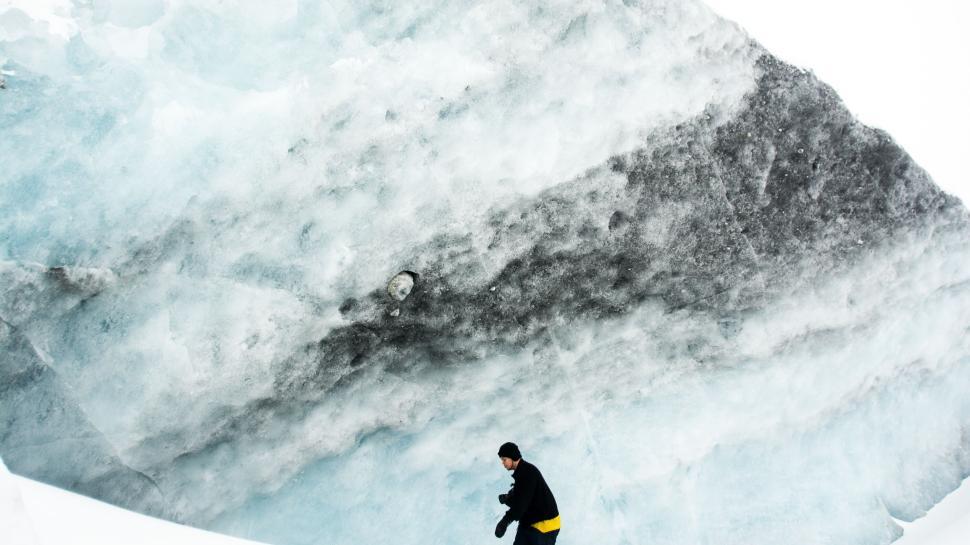 Free Image of Person walking under an impressive ice formation outdoors. 