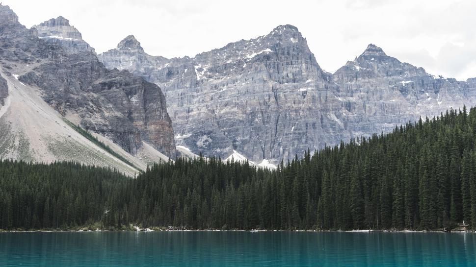 Free Image of Breathtaking view of mountains, forest and turquoise lake. 