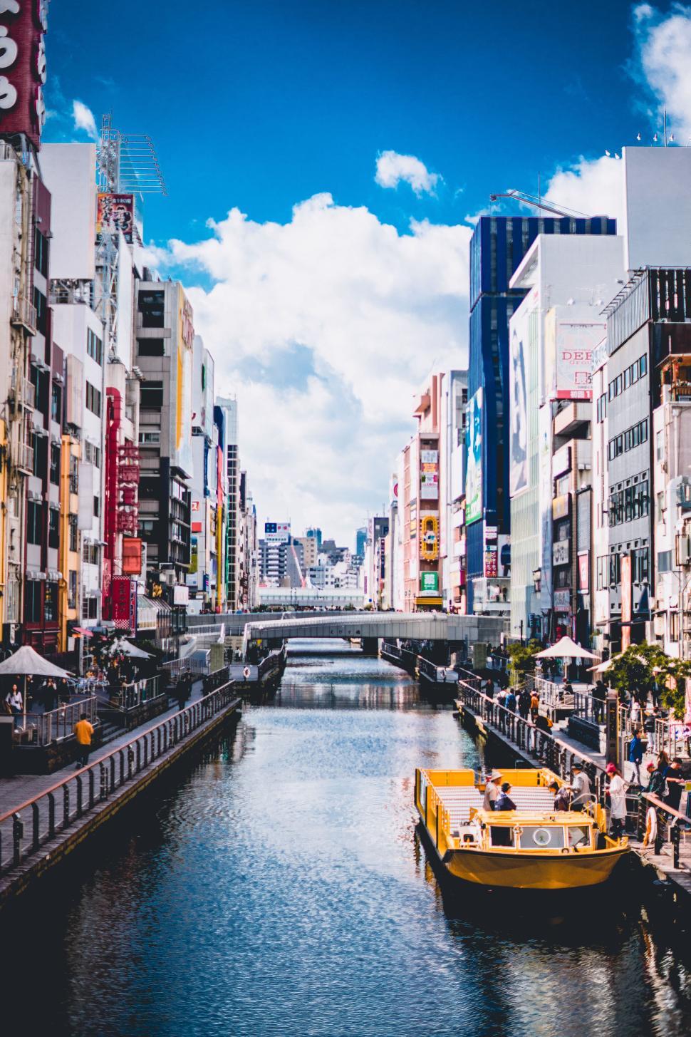 Free Image of Boat on canal in city with vibrant buildings and signs 
