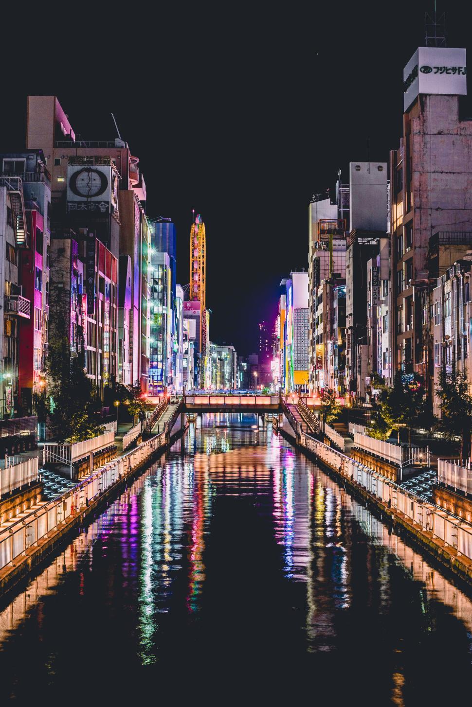 Free Image of Night view of a vibrant waterway through city buildings. 