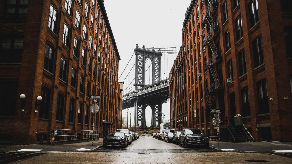 Free Image of Iconic bridge framed by brick buildings on a gray day. 