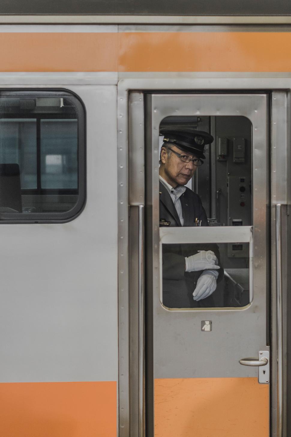 Free Image of Train conductor in uniform in the train doorway. 