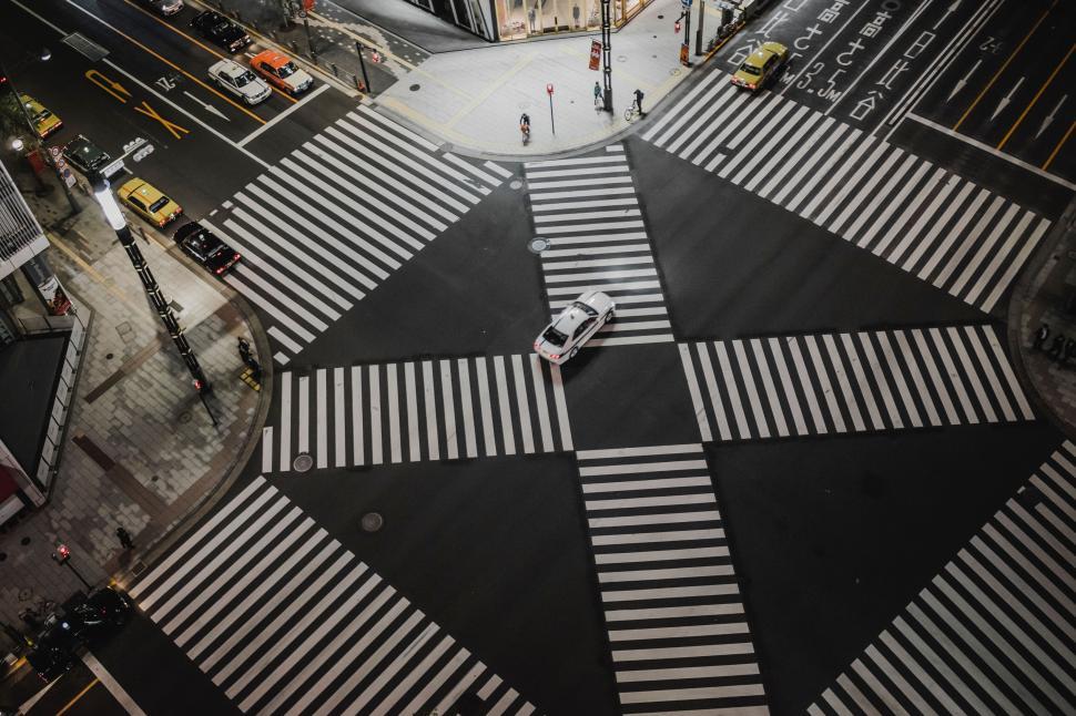 Free Image of Aerial view of a city crosswalk with a single vehicle 