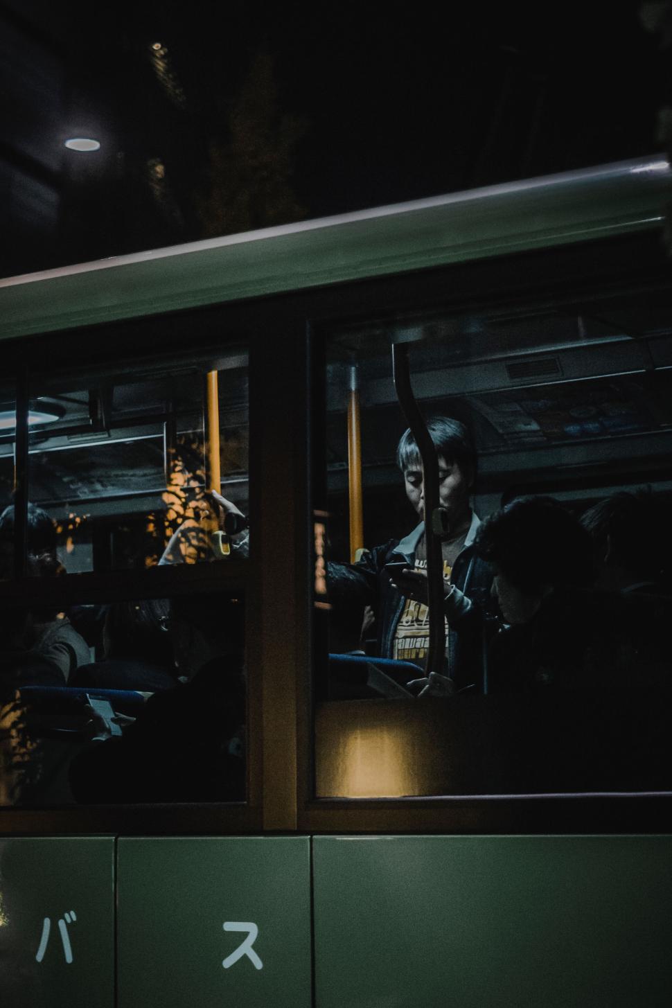 Free Image of Crowded night bus with passengers standing and holding rails. 