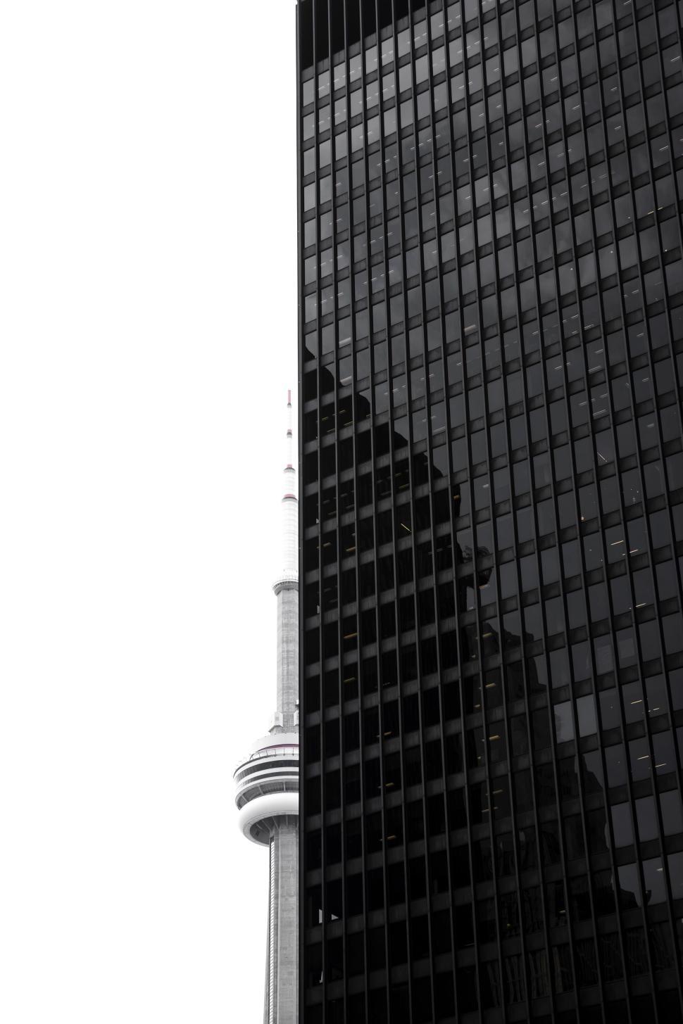 Free Image of Modern skyscraper reflecting the CN Tower s silhouette 