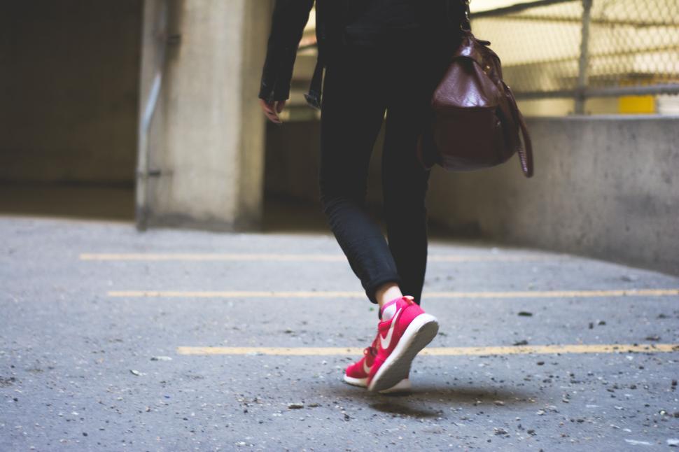 Free Image of Person walking in parking lot wearing bright red shoes. 