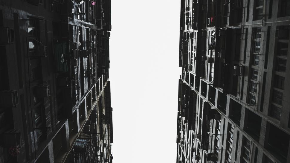 Free Image of Tall buildings framing a bright open sky in an urban scene 