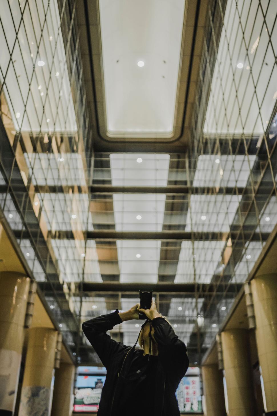 Free Image of Photographer taking a shot in a high-rise building lobby. 