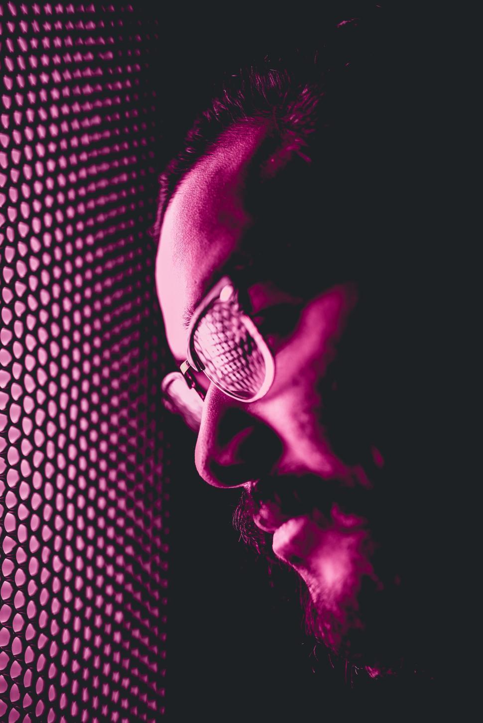 Free Image of Moody portrait of a man in glasses with dramatic lighting. 